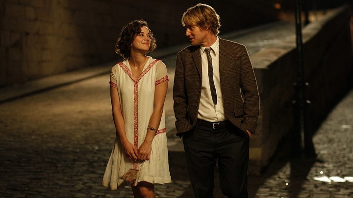 A woman and man walk down the street in Paris in Midnight in Paris.