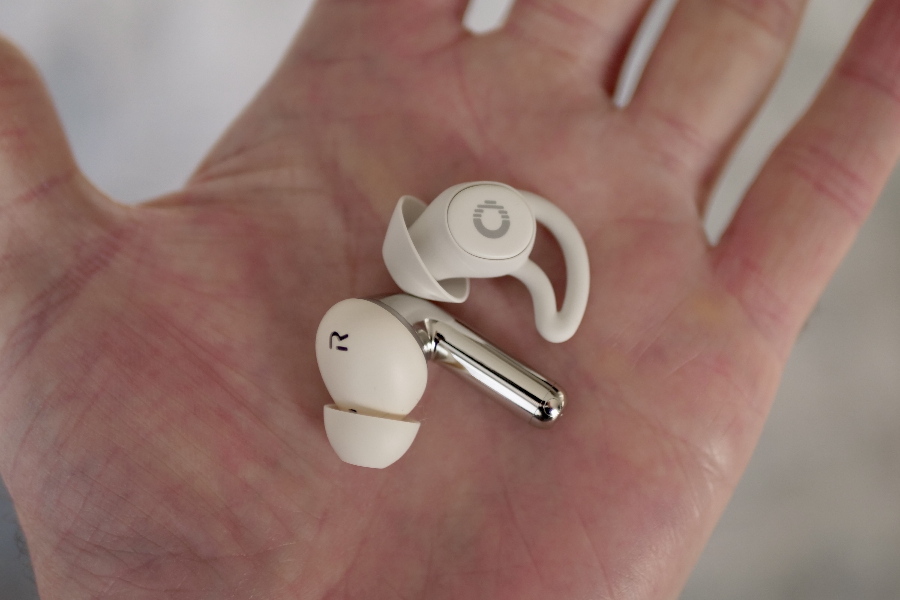 A size comparison showing the Ozlo Sleepbuds with the OnePlus Buds Pro 3.